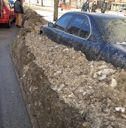 В Запорожье коммунальщики закопали в снег BMW